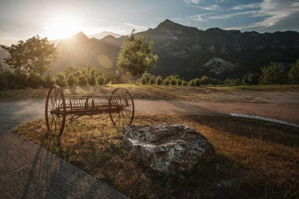 Antico rastrello agricolo nel giardino con vista sui monti al tramonto